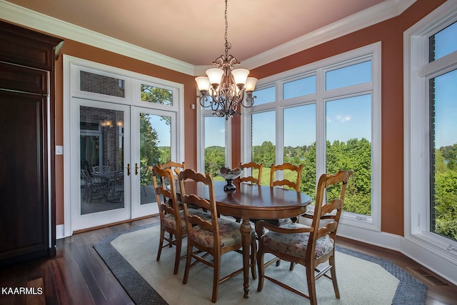 dining area with a notable chandelier, ornamental molding, dark wood-type flooring, and french doors