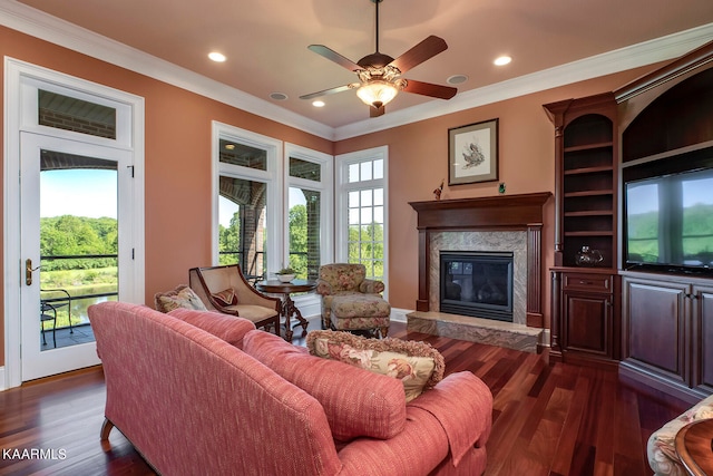 living room featuring ceiling fan, ornamental molding, dark hardwood / wood-style floors, and a premium fireplace