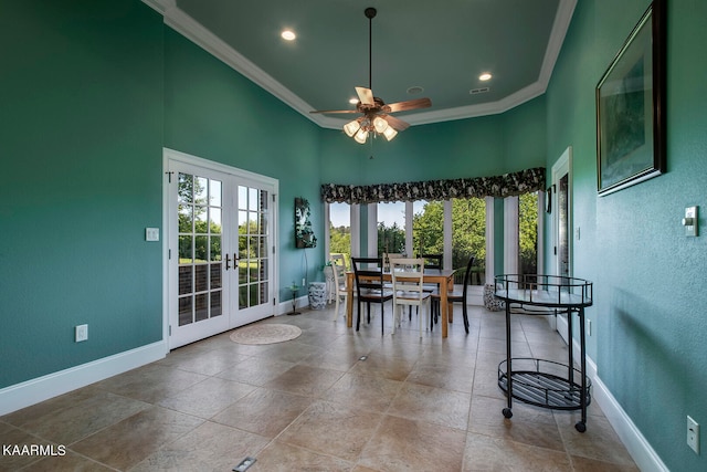 dining room with french doors, ceiling fan, light tile floors, and a towering ceiling