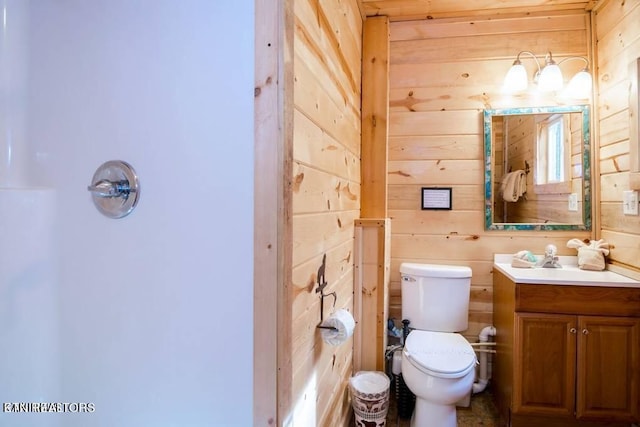 bathroom featuring wood walls, vanity, and toilet