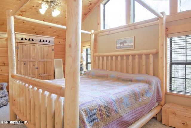 carpeted bedroom featuring wood walls, multiple windows, and wooden ceiling