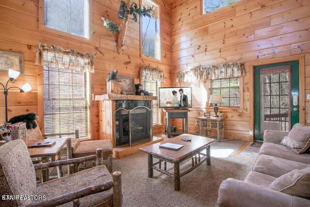 carpeted living room featuring a high ceiling and wood walls