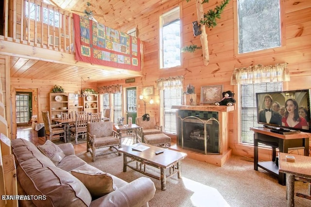 living room with wooden ceiling, a healthy amount of sunlight, wood walls, and ceiling fan