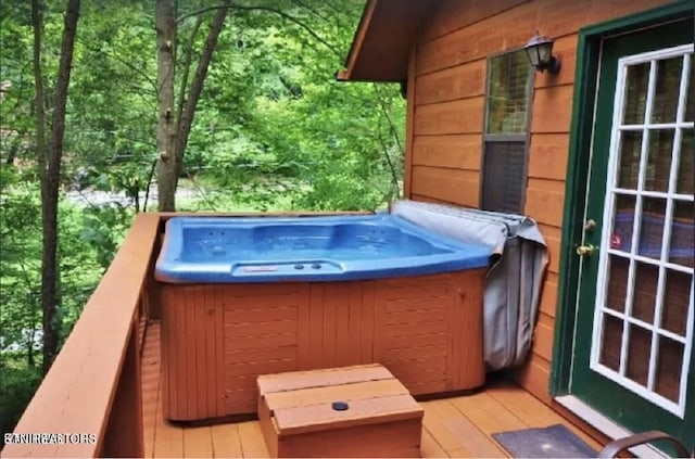 view of swimming pool featuring a deck and a hot tub