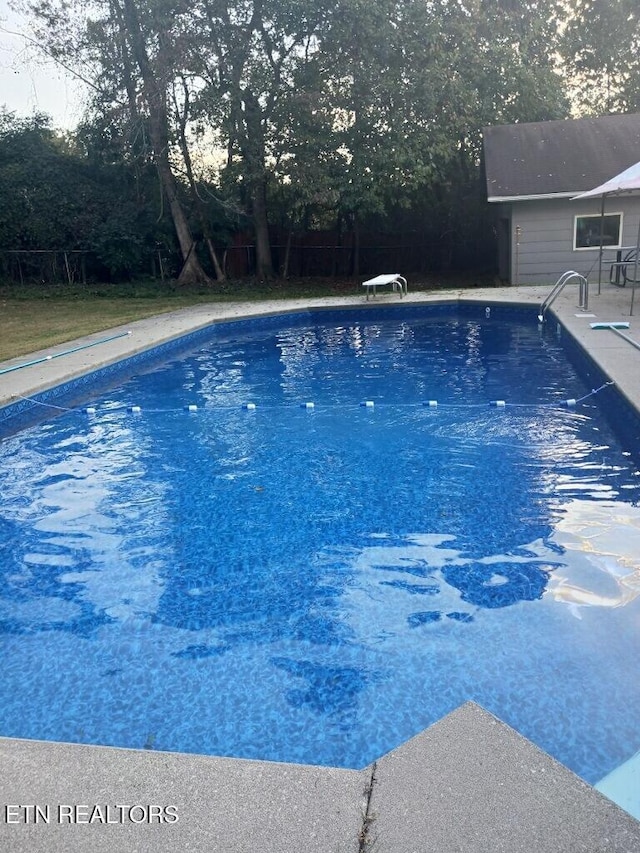 pool with a diving board and a patio