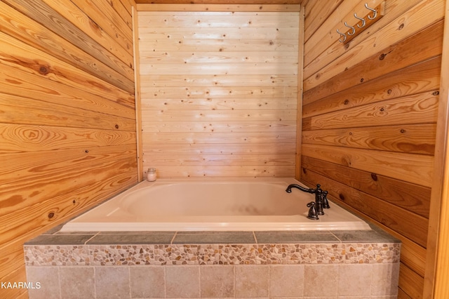 bathroom with a relaxing tiled bath and wooden walls