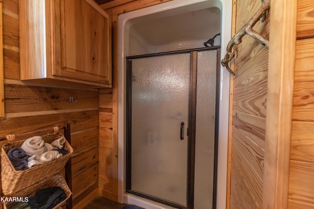 bathroom with wooden walls and a shower with door