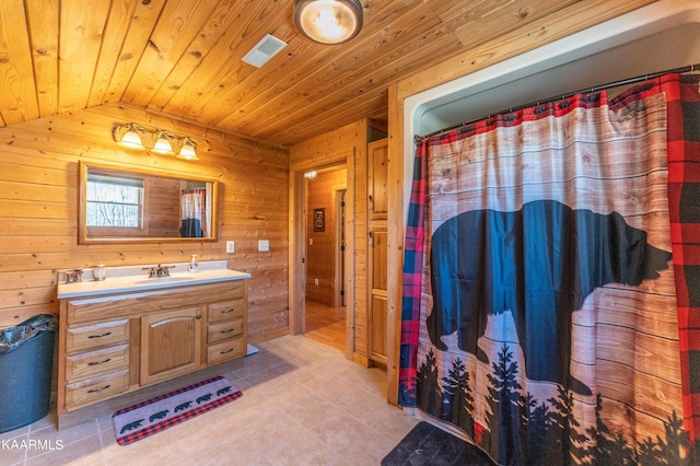 bathroom featuring tile flooring, wood walls, vaulted ceiling, wood ceiling, and vanity with extensive cabinet space