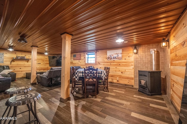 interior space with decorative columns, a wood stove, and dark hardwood / wood-style flooring