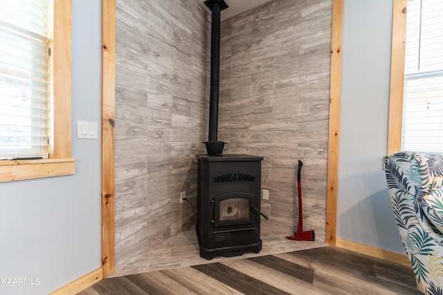 details featuring a wood stove and wood-type flooring