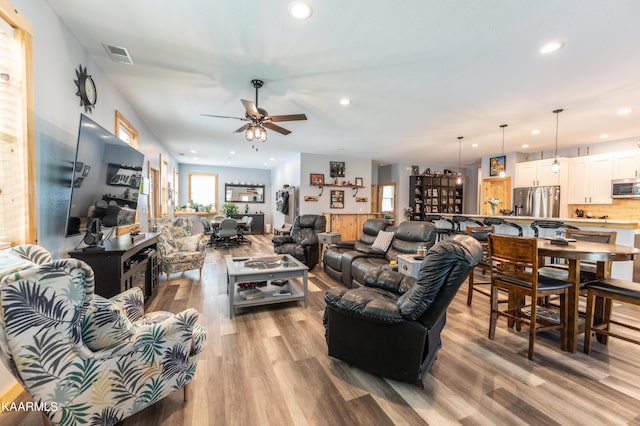 living room with ceiling fan and light wood-type flooring