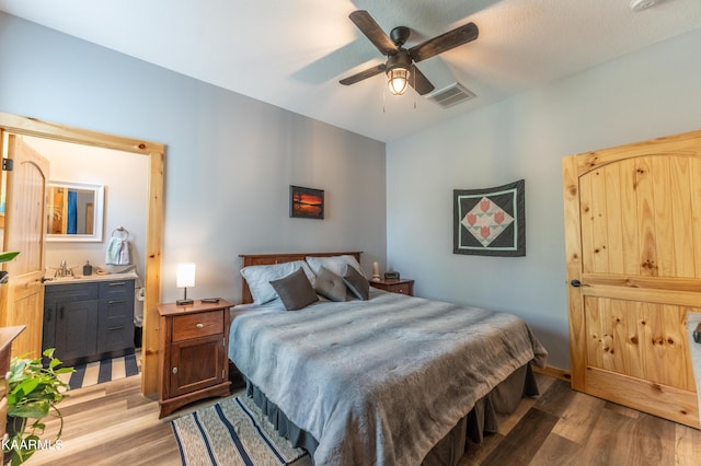 bedroom featuring ensuite bath, ceiling fan, and light hardwood / wood-style flooring