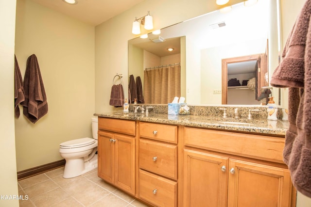 bathroom featuring toilet, vanity, tile patterned flooring, and walk in shower