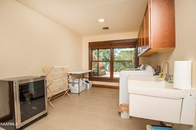 laundry area featuring cabinets, washer and dryer, wine cooler, and sink