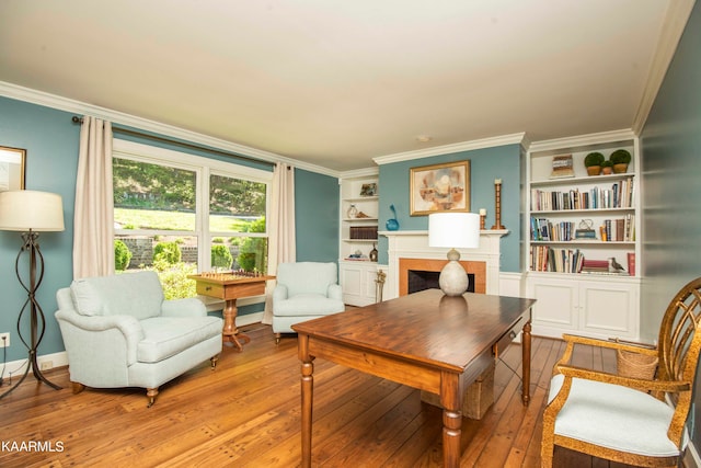 living area with built in features, light hardwood / wood-style flooring, and ornamental molding