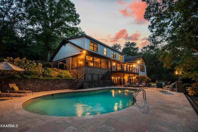 pool at dusk with a patio