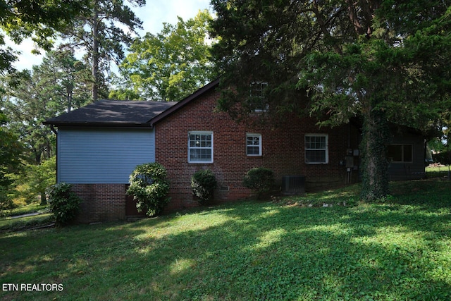 view of side of home featuring a yard and central air condition unit