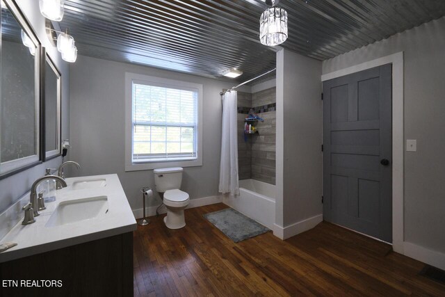 full bathroom with shower / bath combination with curtain, toilet, hardwood / wood-style flooring, and vanity