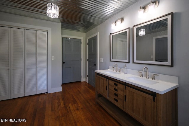 bathroom featuring hardwood / wood-style floors, an inviting chandelier, and vanity