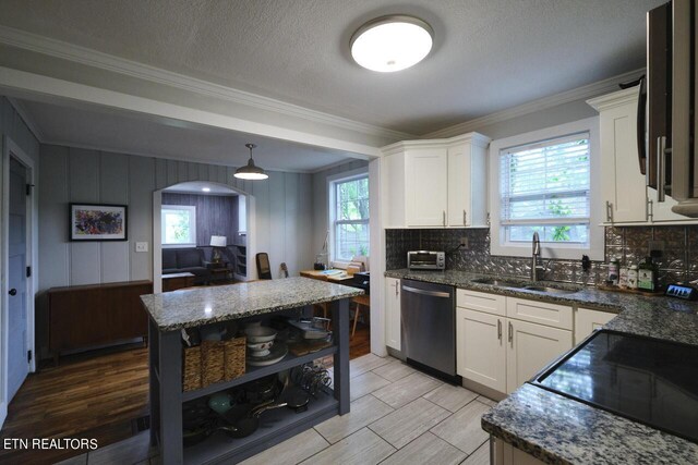 kitchen with crown molding, dark stone counters, stainless steel appliances, and sink