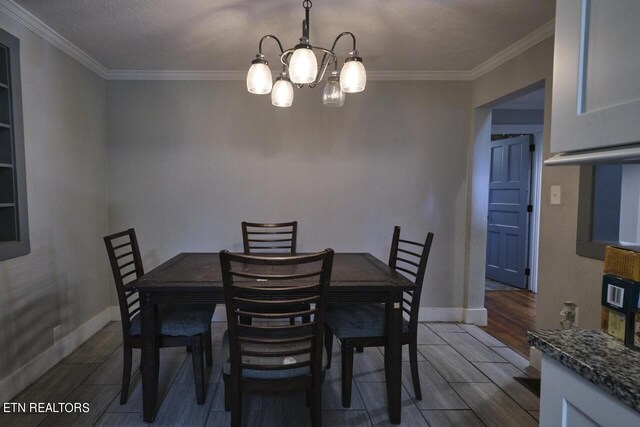 dining space featuring a textured ceiling, crown molding, hardwood / wood-style floors, and a chandelier