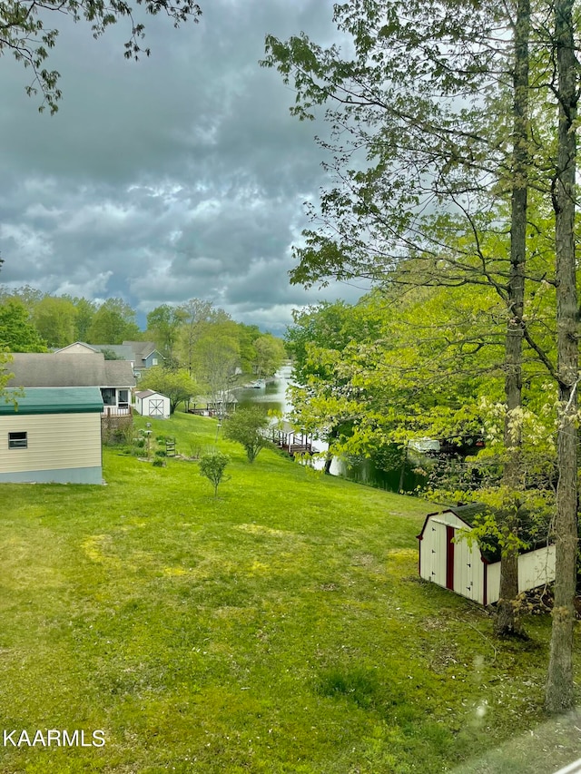 view of yard featuring a water view and an outdoor structure