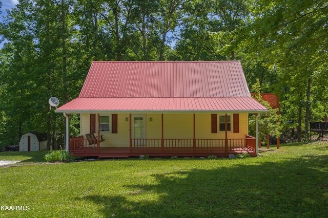 farmhouse with a front lawn, a storage unit, and covered porch