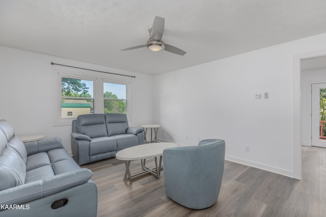 living room featuring a textured ceiling, ceiling fan, and hardwood / wood-style flooring