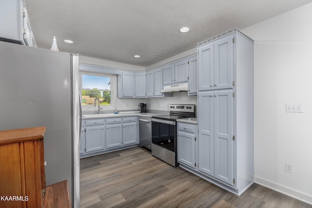 kitchen featuring hardwood / wood-style floors, stainless steel appliances, a textured ceiling, and sink