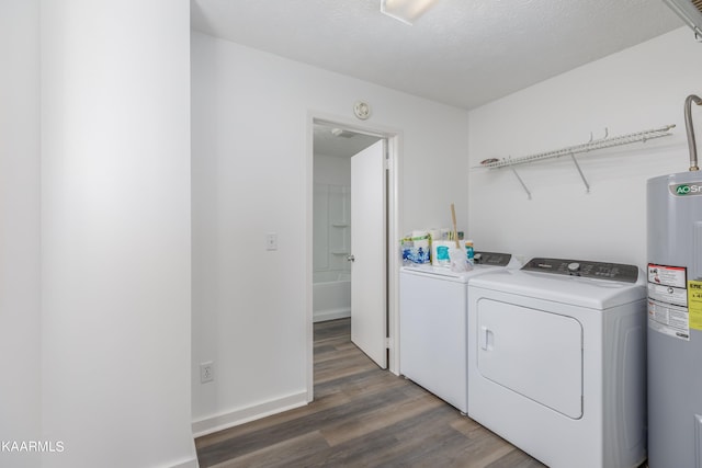 laundry area featuring dark hardwood / wood-style flooring, water heater, a textured ceiling, and washing machine and dryer