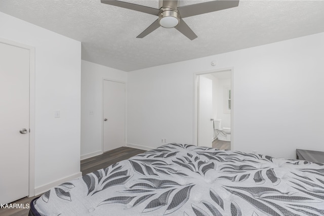 bedroom with a textured ceiling, ensuite bath, ceiling fan, and dark hardwood / wood-style floors