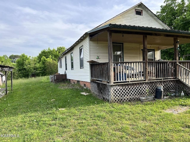 back of property with a deck and a lawn