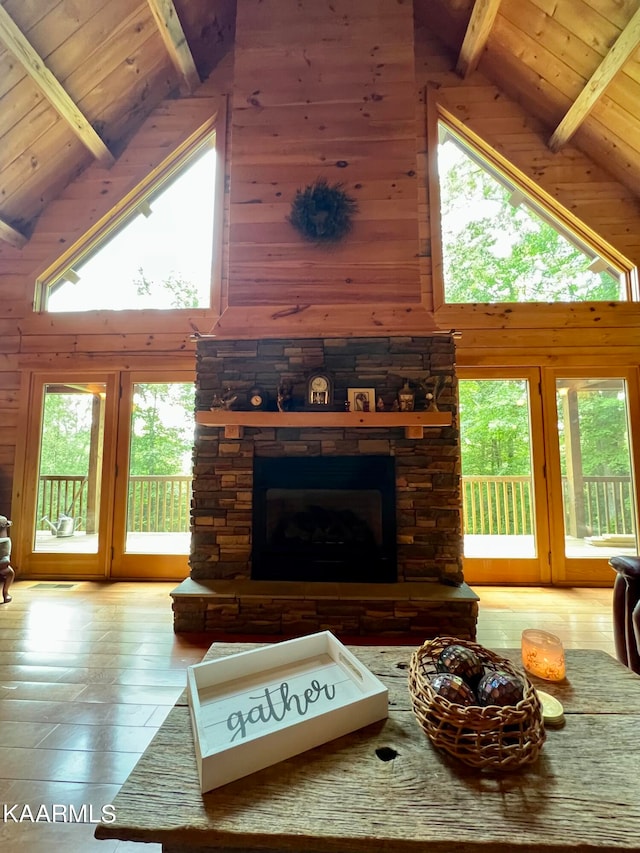 living room featuring wood walls, beamed ceiling, and light hardwood / wood-style floors