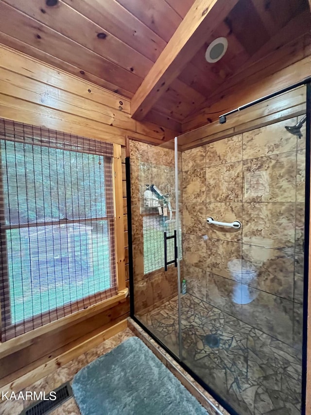 bathroom featuring wooden walls, a shower with door, lofted ceiling with beams, and wood ceiling