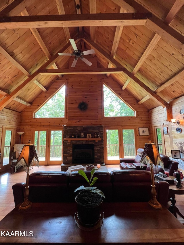 living room with wood walls, beamed ceiling, wood-type flooring, and high vaulted ceiling