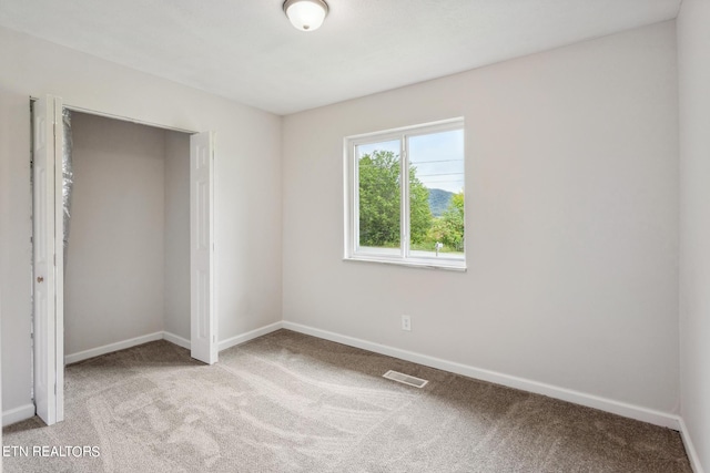 unfurnished bedroom featuring a closet and carpet floors