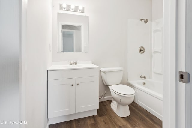 full bathroom with toilet, hardwood / wood-style flooring, vanity, and tub / shower combination