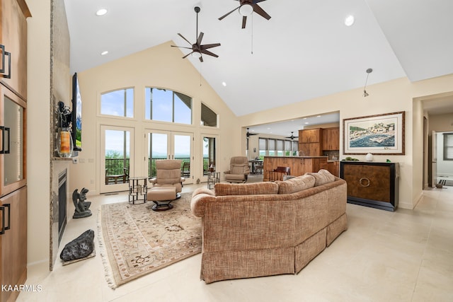 tiled living room with ceiling fan and high vaulted ceiling