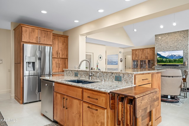 kitchen with light stone countertops, stainless steel appliances, light tile floors, and sink