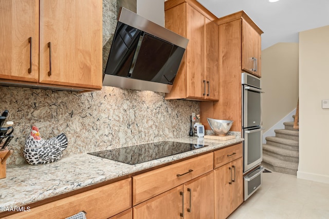 kitchen featuring backsplash, black electric cooktop, light stone counters, and light tile flooring