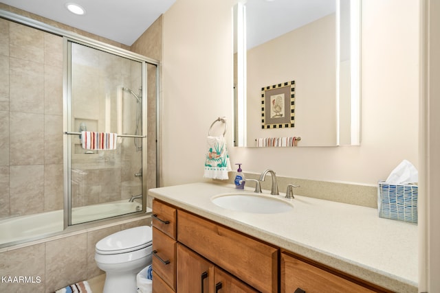 full bathroom with toilet, combined bath / shower with glass door, and vanity with extensive cabinet space