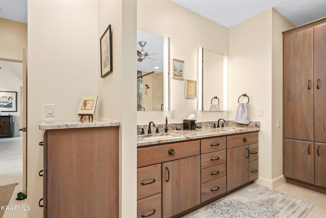 bathroom featuring ceiling fan, dual sinks, tile floors, and vanity with extensive cabinet space