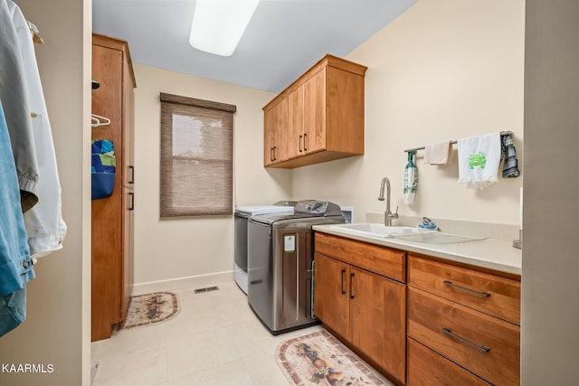 washroom featuring light tile floors, sink, washer hookup, independent washer and dryer, and cabinets