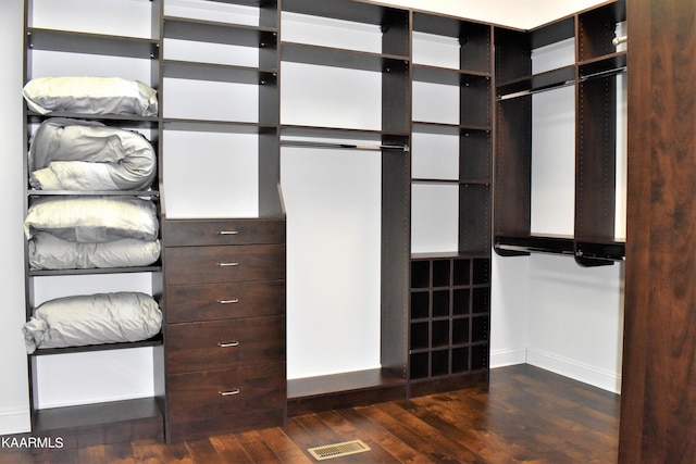 walk in closet with dark wood-type flooring