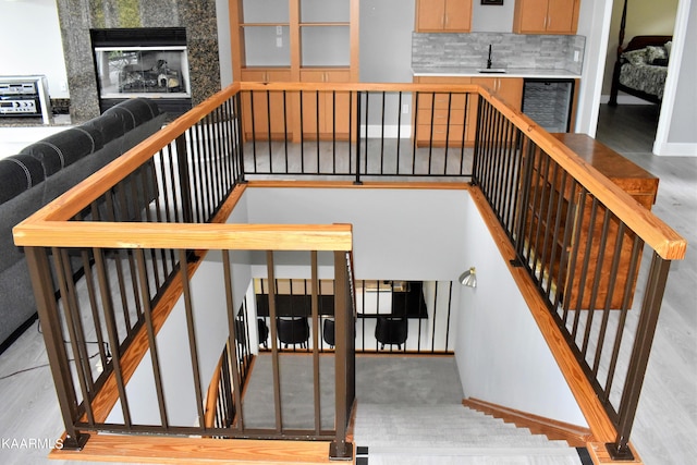 stairway with sink and light hardwood / wood-style flooring