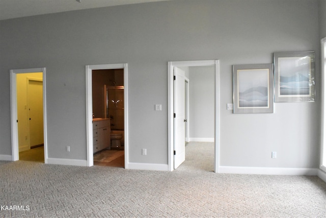 unfurnished bedroom with connected bathroom and light colored carpet