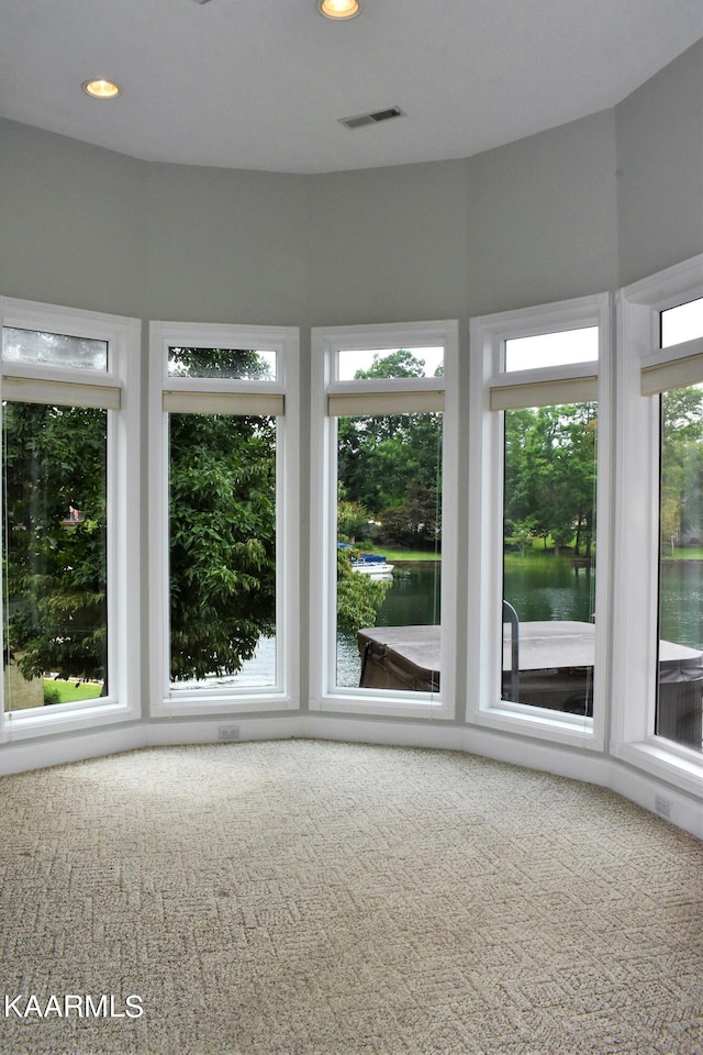 unfurnished sunroom with a water view