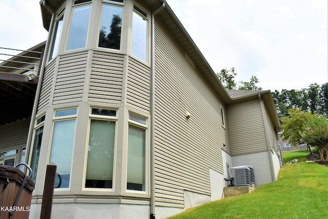 view of property exterior featuring central AC unit and a yard