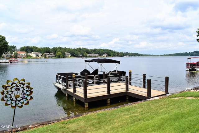 view of dock with a lawn and a water view