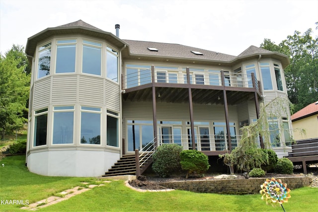 back of house with a lawn and a balcony